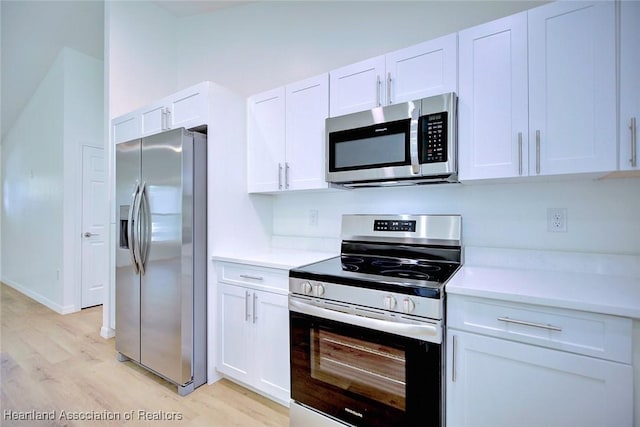 kitchen featuring white cabinets, stainless steel appliances, and light hardwood / wood-style flooring