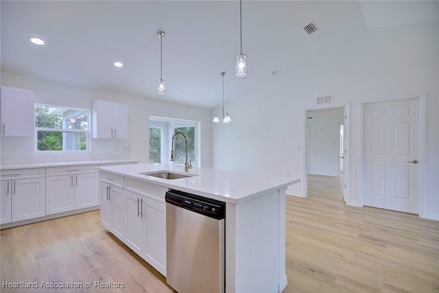 kitchen with stainless steel dishwasher, a kitchen island with sink, sink, decorative light fixtures, and white cabinets