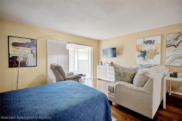 bedroom featuring a textured ceiling and dark wood-type flooring