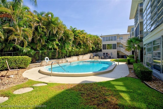 view of pool with a lawn