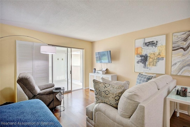 living room with wood-type flooring and a textured ceiling