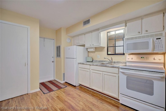 kitchen with white cabinetry, sink, light hardwood / wood-style flooring, and white appliances