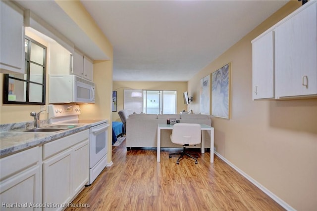 kitchen featuring sink, white appliances, white cabinets, and light hardwood / wood-style flooring