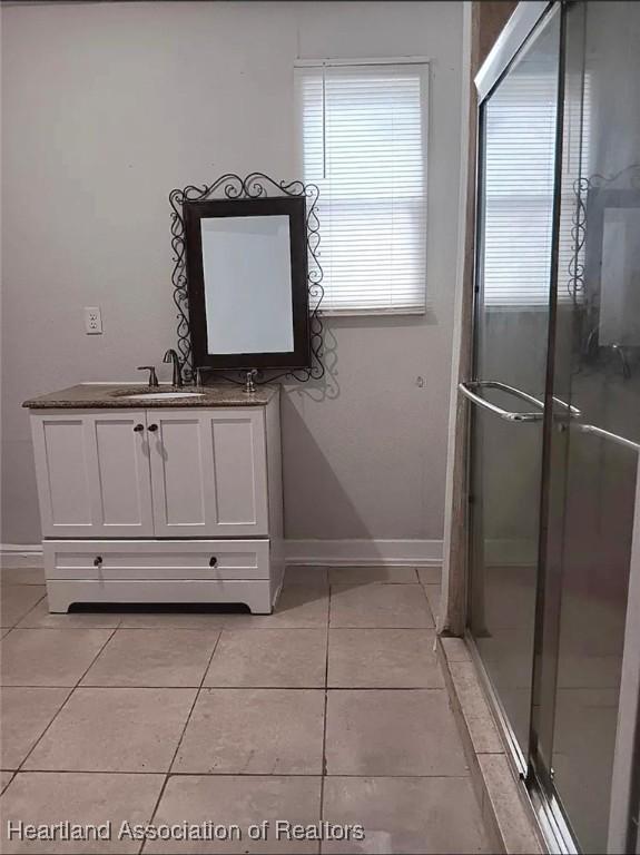 bathroom featuring an enclosed shower, vanity, and tile patterned floors