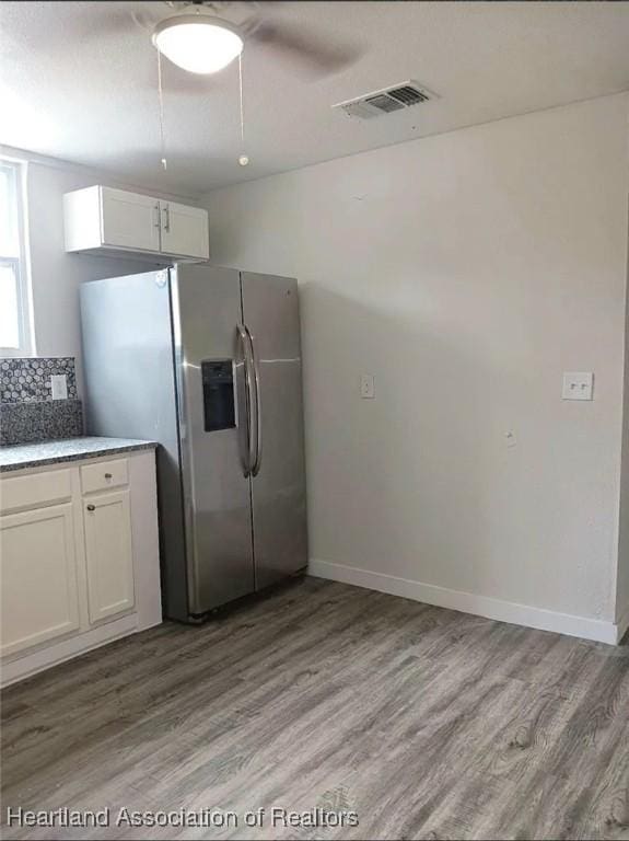 kitchen featuring white cabinetry, light hardwood / wood-style floors, stainless steel fridge with ice dispenser, and tasteful backsplash