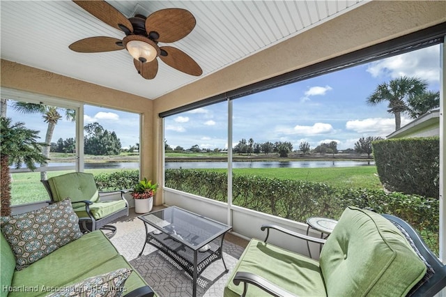 sunroom / solarium featuring ceiling fan and a water view