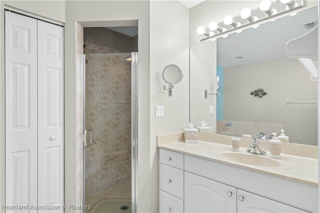 bathroom with a shower with door and vanity