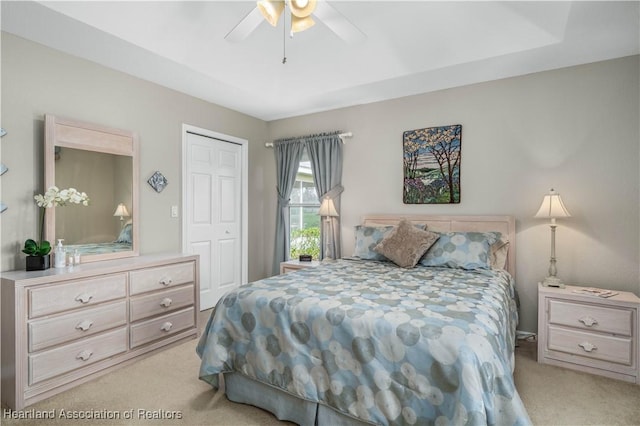 bedroom featuring ceiling fan, light colored carpet, and a closet