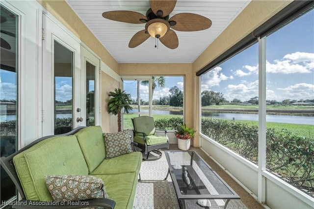 sunroom / solarium featuring a water view and ceiling fan