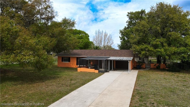 ranch-style house with a front yard, driveway, and an attached carport