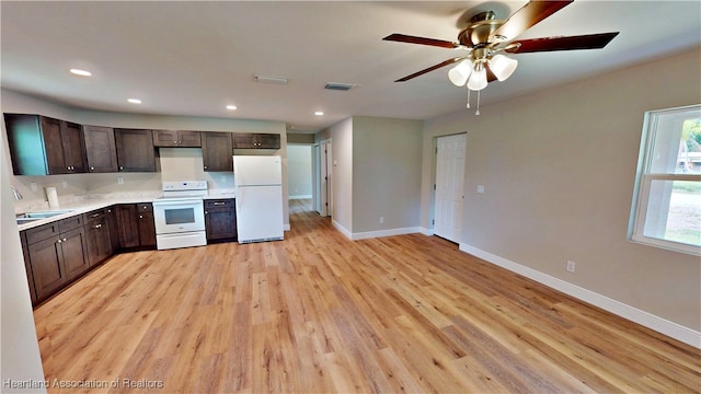 129 Badger Loop, Ona, FL 33865 - kitchen featuring white appliances, dark brown cabinetry, light wood-type flooring, light countertops, and a ceiling fan