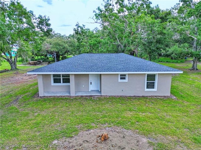 129 Badger Loop, Ona, FL 33865 - ranch-style house with stucco siding, a front yard, a shingled roof, and a patio area