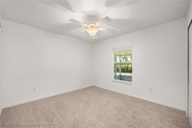 spare room with baseboards, carpet, and a ceiling fan