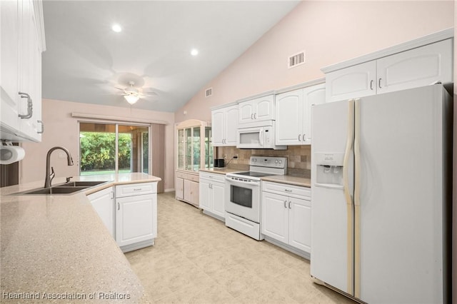 kitchen with visible vents, a sink, white cabinets, and white appliances