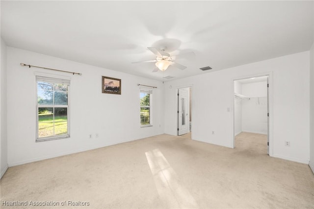 unfurnished bedroom with multiple windows, light carpet, and visible vents