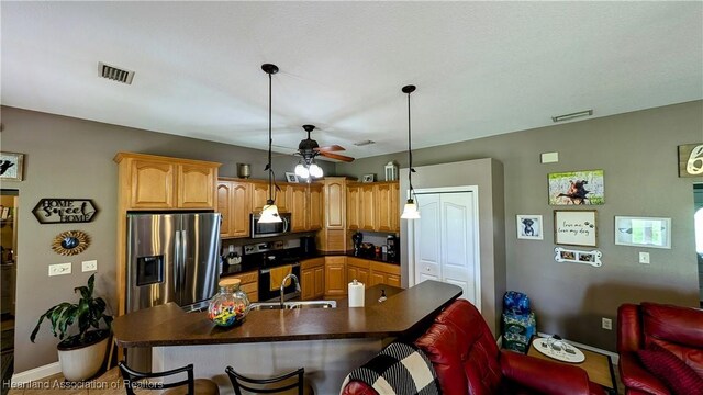 1779 State Road 62nd Rd, Bowling Green, FL 33834 - kitchen with a ceiling fan, dark countertops, visible vents, a kitchen bar, and appliances with stainless steel finishes