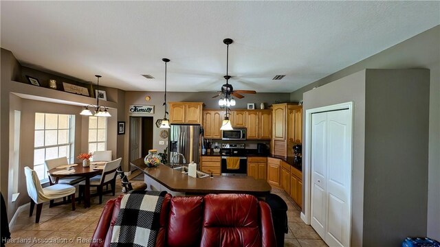 1779 State Road 62nd Rd, Bowling Green, FL 33834 - kitchen featuring ceiling fan, light tile patterned floors, appliances with stainless steel finishes, a sink, and dark countertops