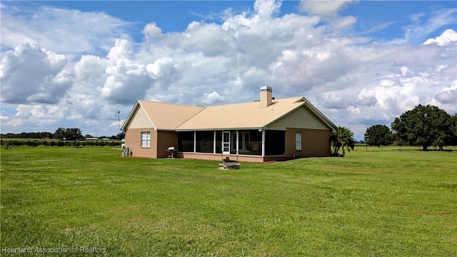 1779 State Road 62nd Rd, Bowling Green, FL 33834 - back of house with a fire pit, a chimney, a sunroom, and a lawn