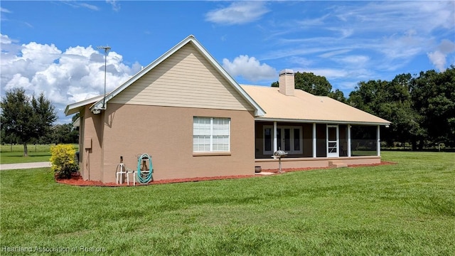 1779 State Road 62nd Rd, Bowling Green, FL 33834 - rear view of house with a yard, a chimney, a sunroom, and stucco siding