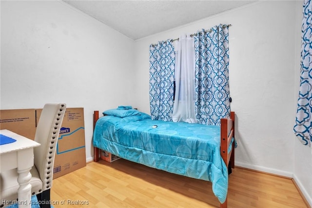 bedroom with baseboards and wood finished floors