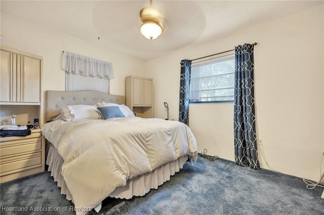 bedroom featuring dark colored carpet and a ceiling fan