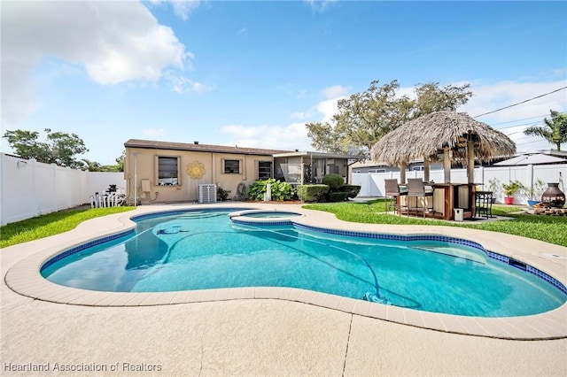 view of swimming pool featuring outdoor dry bar, a patio area, a fenced backyard, and a pool with connected hot tub