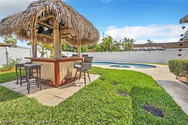 view of yard featuring a fenced in pool, a fenced backyard, outdoor dry bar, and an in ground hot tub