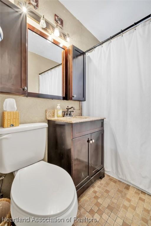 bathroom featuring toilet and vanity