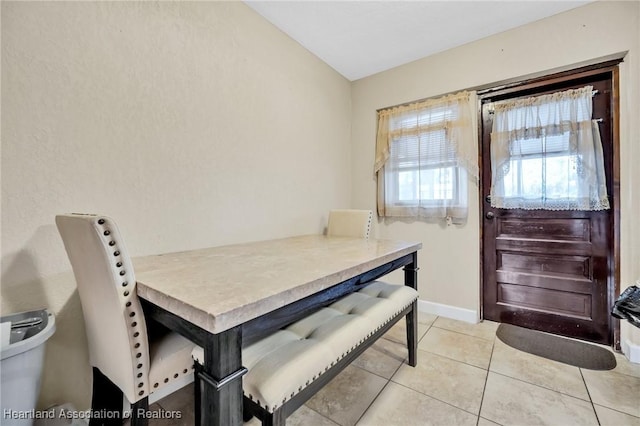 dining area featuring light tile patterned floors and baseboards