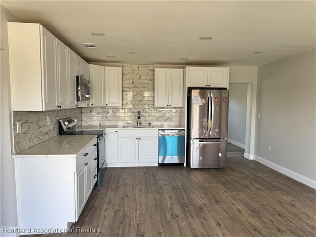 kitchen with white cabinets, sink, stainless steel appliances, and dark wood-type flooring