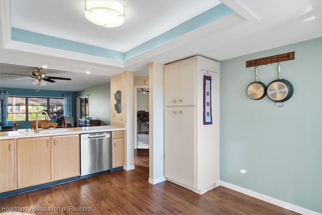 kitchen with stainless steel dishwasher, light countertops, dark wood-style floors, and a sink