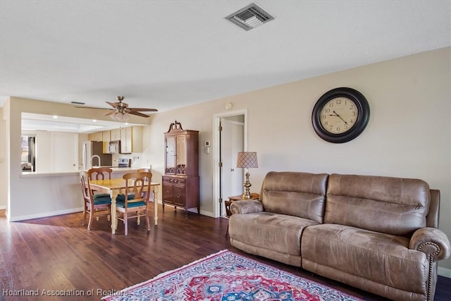 living area with a ceiling fan, baseboards, visible vents, and dark wood-style flooring