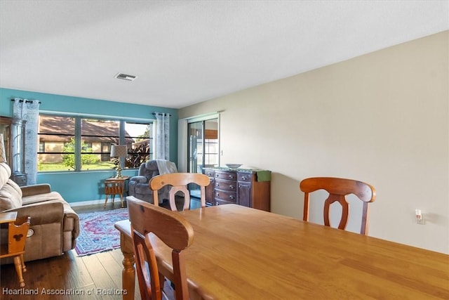 dining room with visible vents, baseboards, and wood finished floors