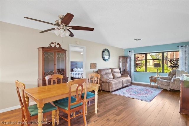 dining space with visible vents, baseboards, wood finished floors, and a ceiling fan