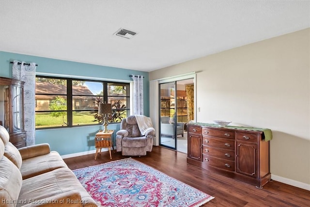 living room with dark wood finished floors, baseboards, and visible vents