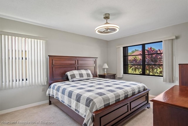 bedroom featuring baseboards and light carpet