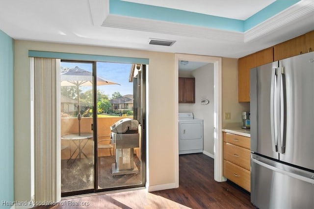 doorway with a tray ceiling, visible vents, baseboards, and dark wood-style flooring