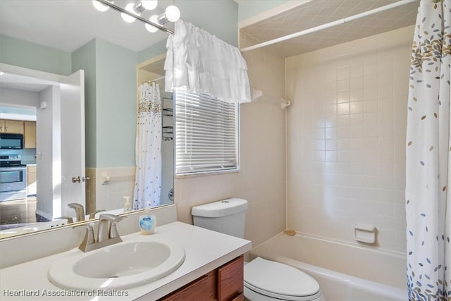 bathroom featuring shower / bath combination with curtain, toilet, and vanity