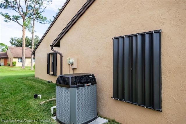 exterior details featuring central air condition unit, electric meter, and stucco siding