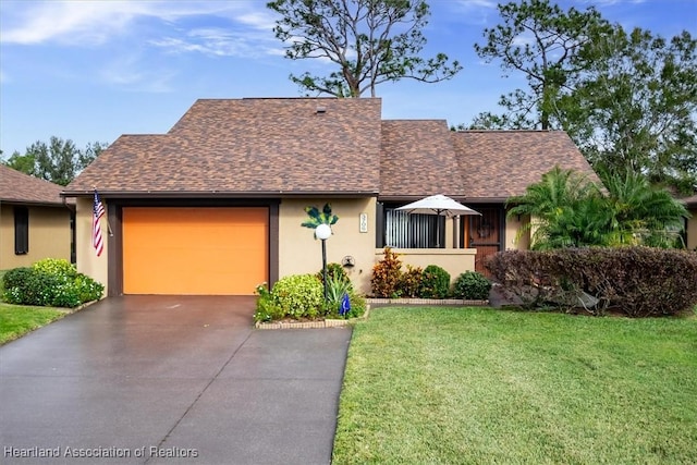 view of front facade with roof with shingles, an attached garage, stucco siding, concrete driveway, and a front lawn