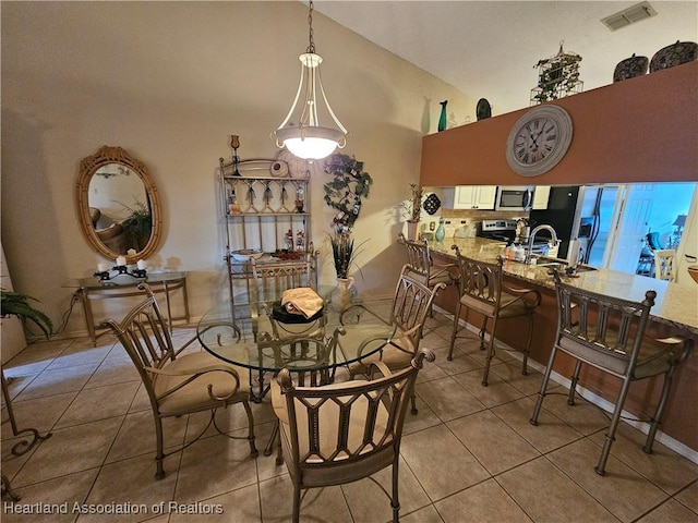 dining area with light tile patterned floors and high vaulted ceiling