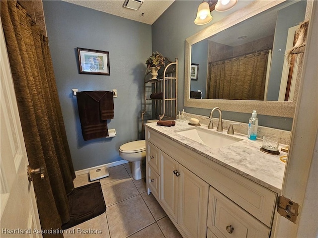 bathroom with tile patterned flooring, a textured ceiling, vanity, and toilet