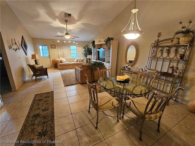 dining area featuring ceiling fan, lofted ceiling, and light tile patterned flooring