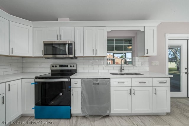 kitchen with white cabinetry, appliances with stainless steel finishes, sink, and tasteful backsplash