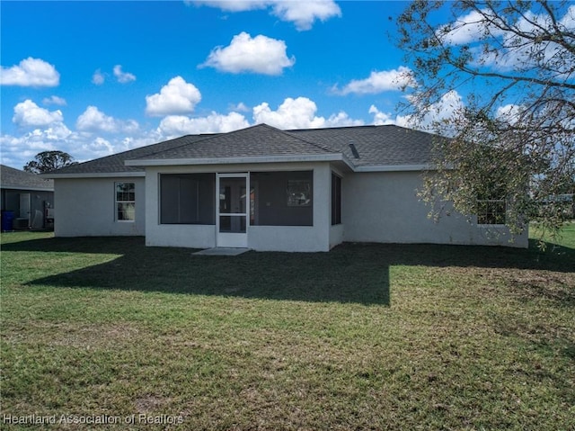 rear view of house with a sunroom, a yard, and central AC