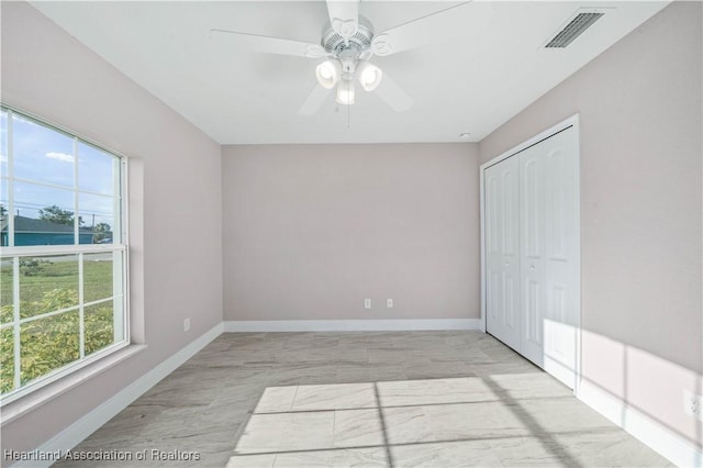 unfurnished bedroom with ceiling fan and a closet