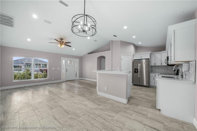 kitchen with sink, white cabinetry, appliances with stainless steel finishes, a kitchen island, and backsplash