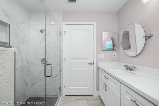 bathroom with vanity and a shower with door