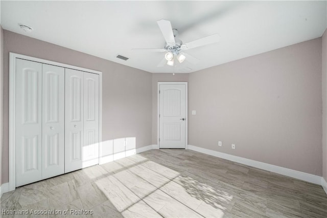 unfurnished bedroom featuring ceiling fan and a closet