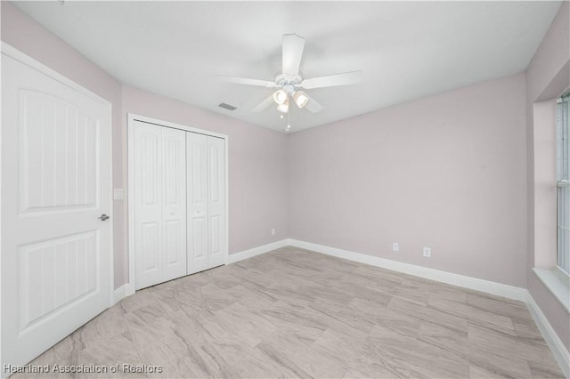 unfurnished bedroom featuring ceiling fan and a closet